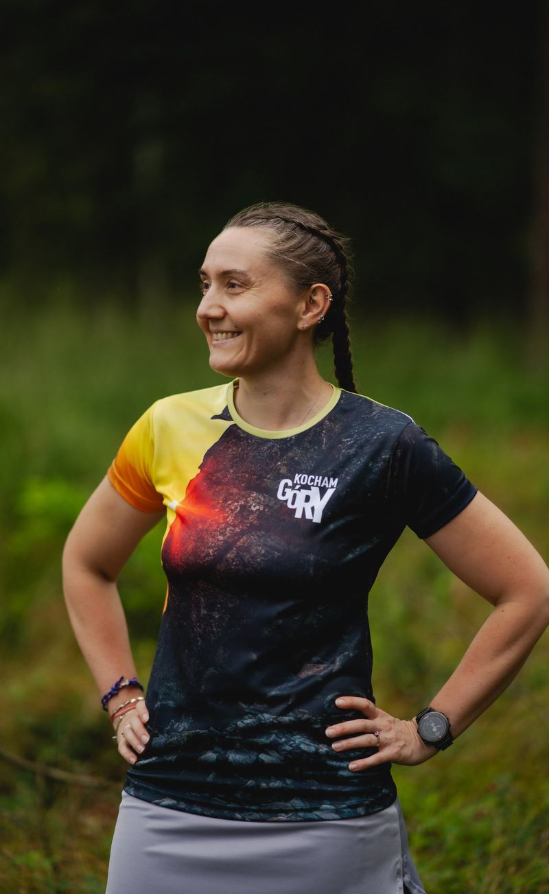 Smiling woman in a dark mountain-print running shirt
